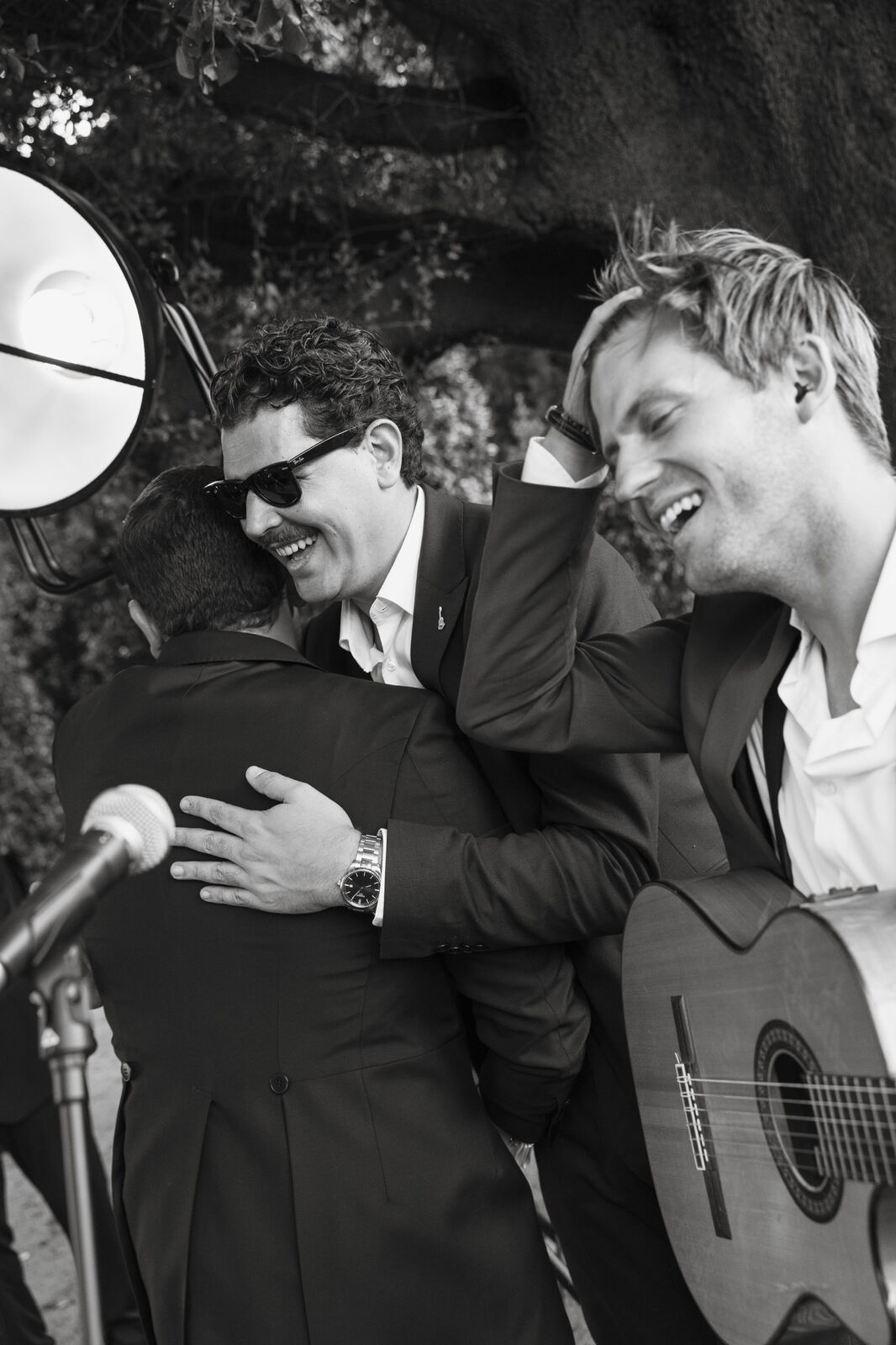 Músicos abrazando a un invitado junto al micrófono