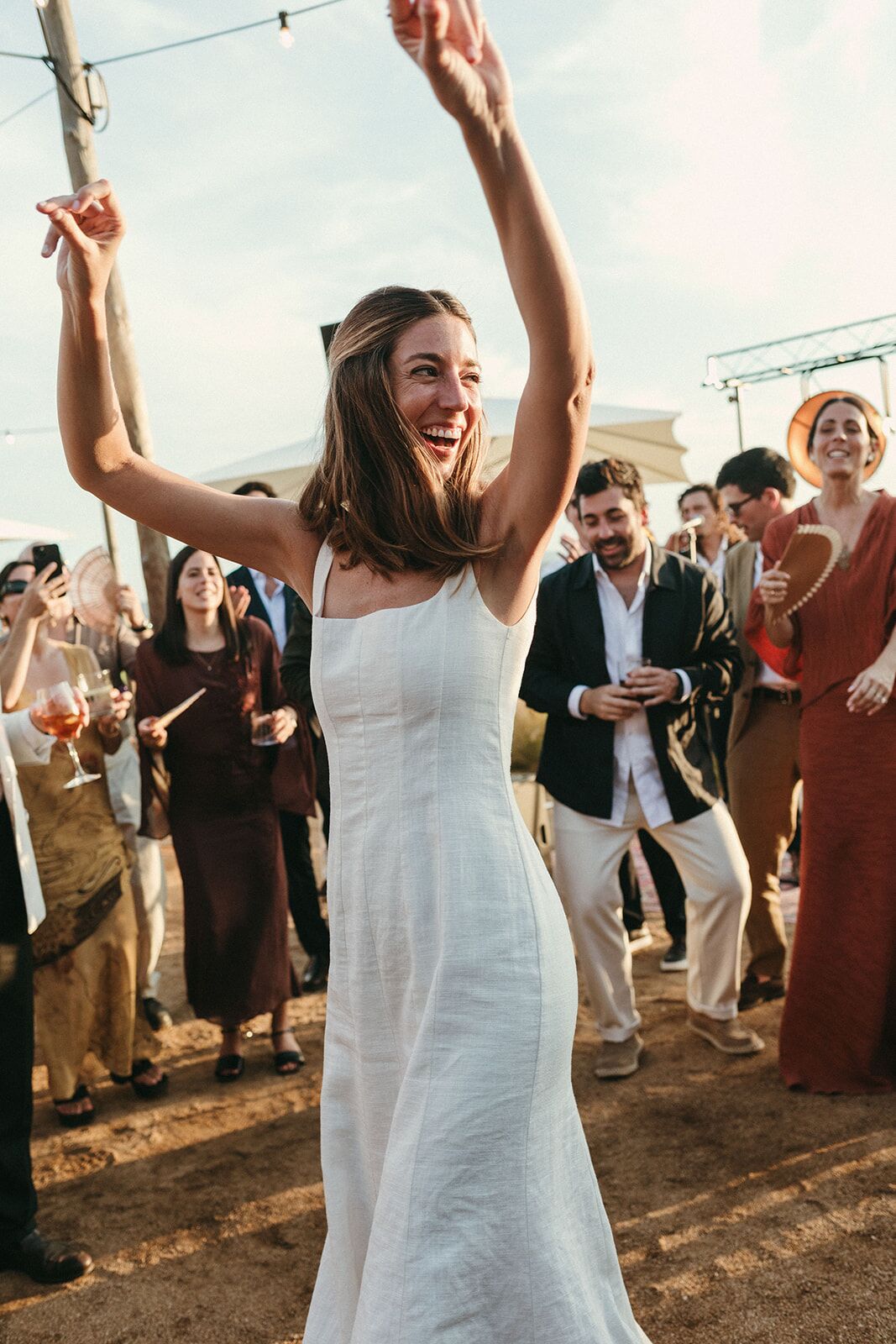 La novia bailando con los brazos en alto
